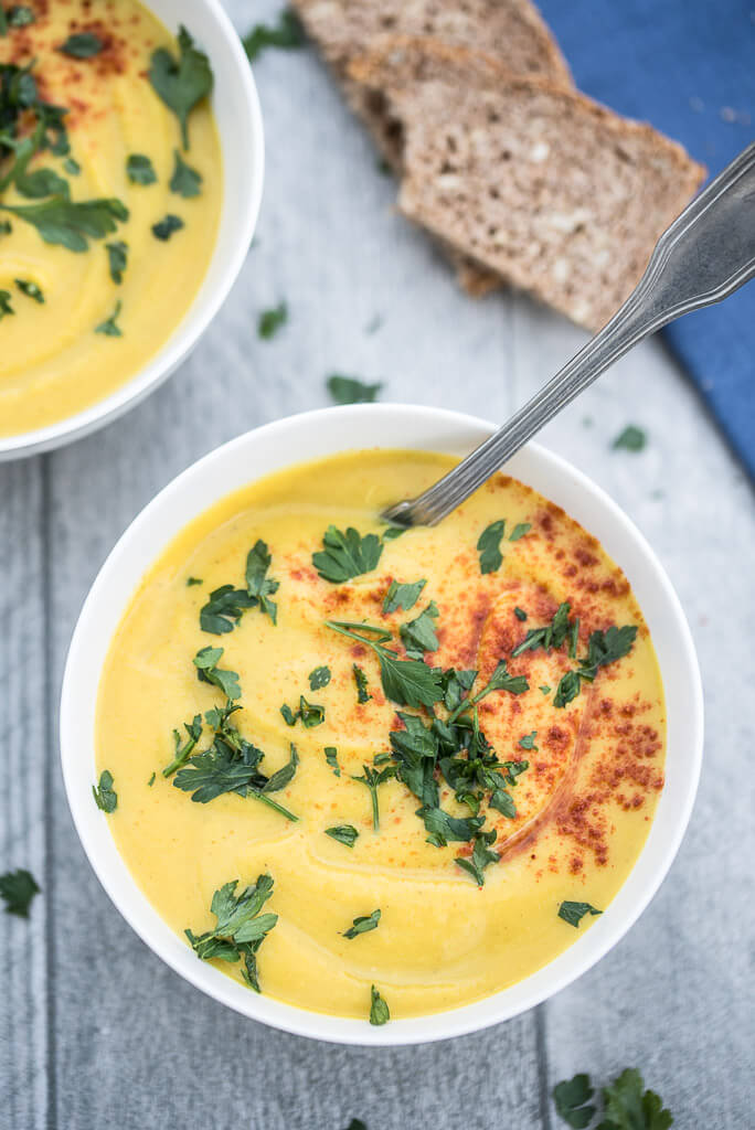 Easy Roasted Butternut Squash Soup Recipe topped with fresh parsley, paprika and served with bread