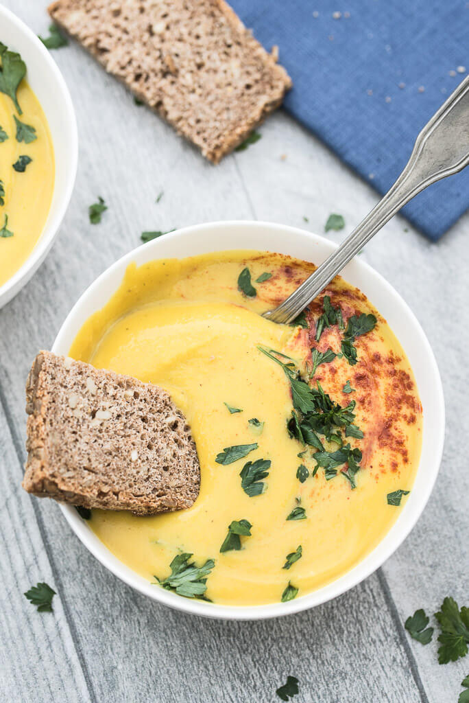 Easy Roasted Butternut Squash Soup Recipe topped with fresh parsley, paprika and served with bread