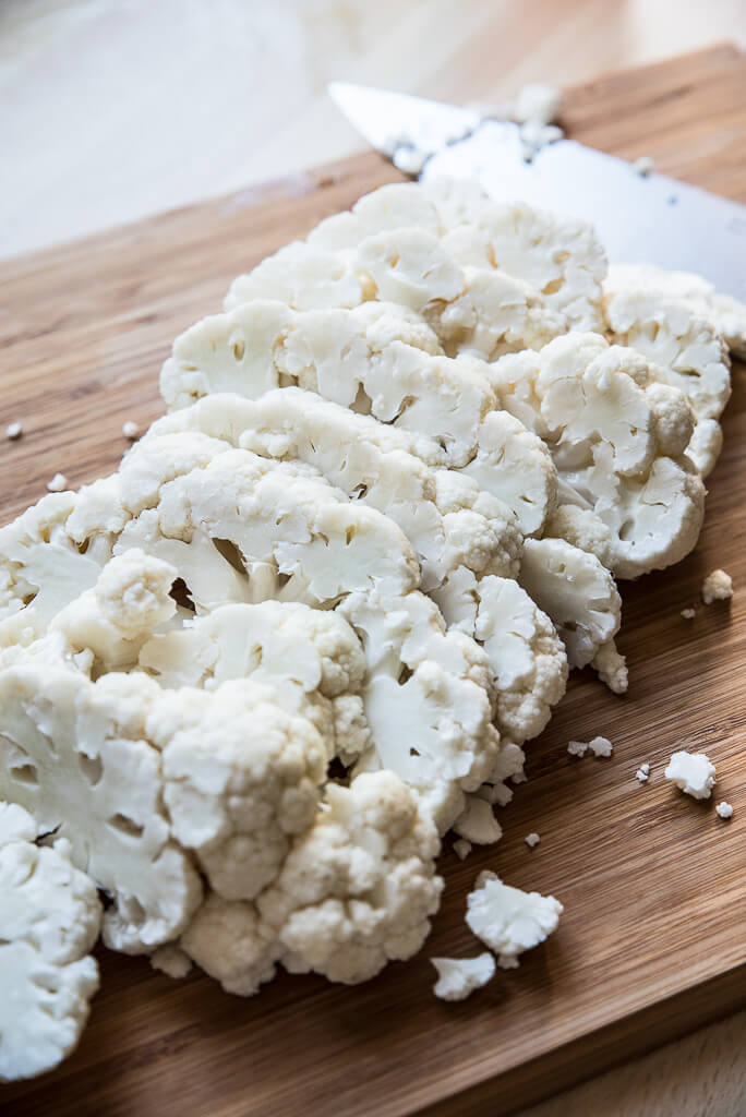 cut up cauliflower slices or cauliflower steaks on cutting board